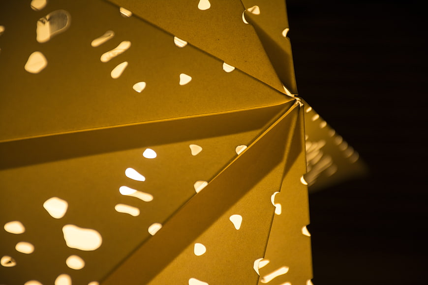 Close-up of yellow paper lantern with cut-out patterns