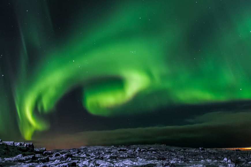 Green Aurora Borealis Over Snowy Icelandic Landscape