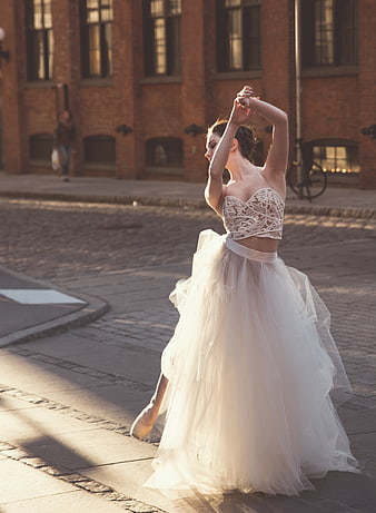 Ballerina in White Lace Tutu Dancing on Cobblestone Street