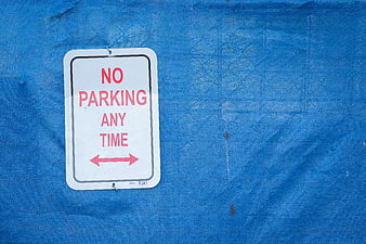 No Parking Any Time Sign on Blue Tarp Background