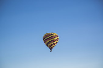 Yellow and red hot air balloon in clear blue sky