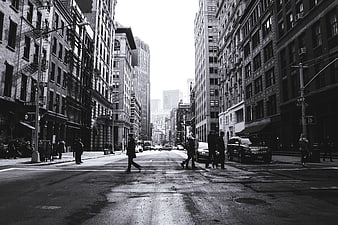 Black and white urban street scene with pedestrians crossing
