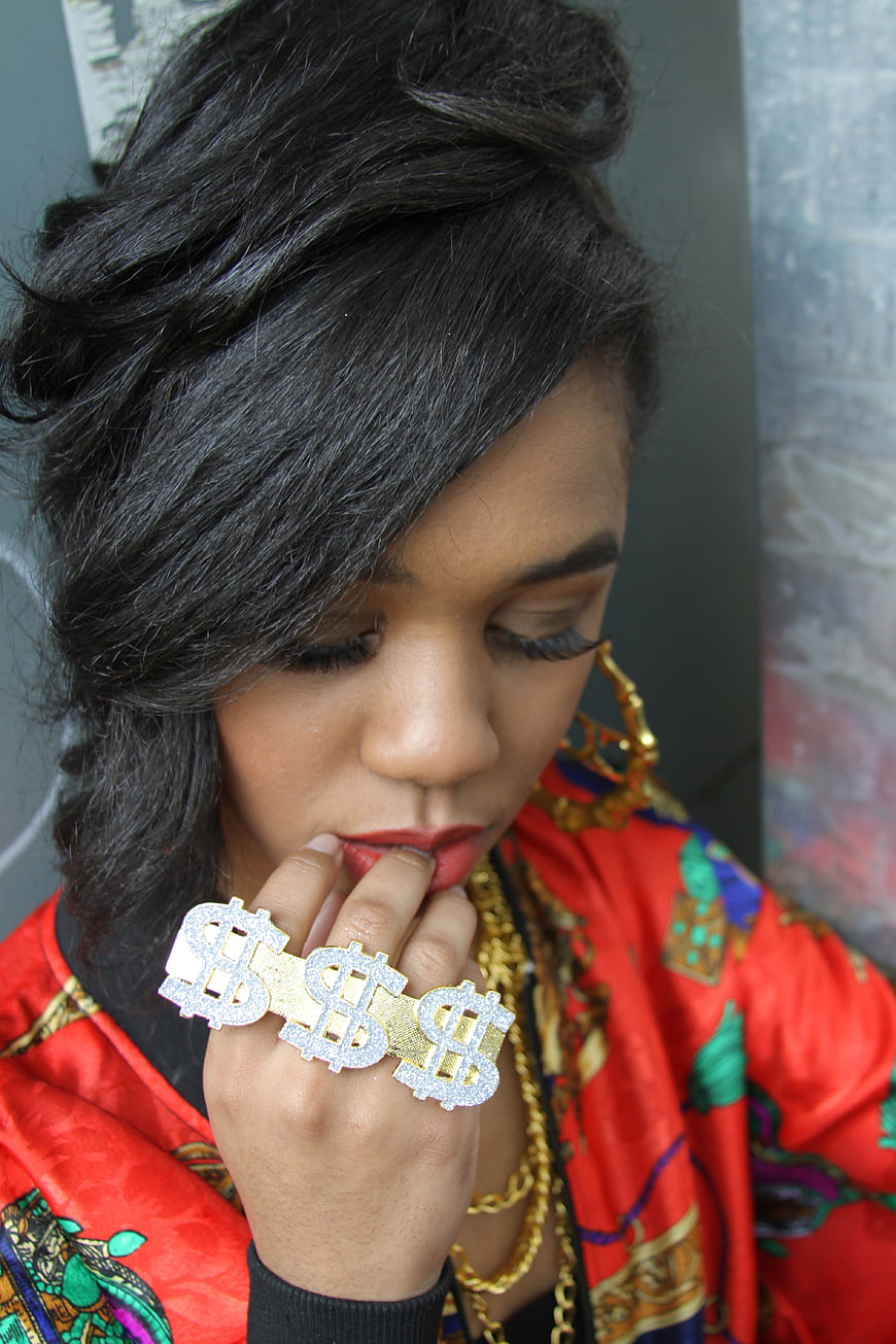 Woman with Dollar Sign Rings and Gold Jewelry