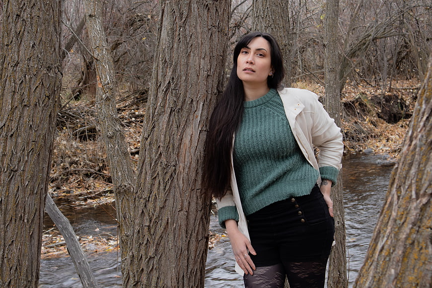Woman in Green Sweater Standing by River in Forest