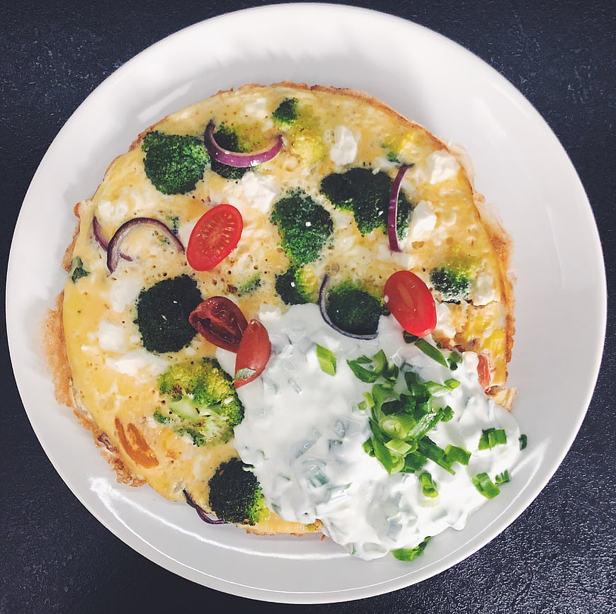 Overhead shot of vegetable omelet with yogurt sauce