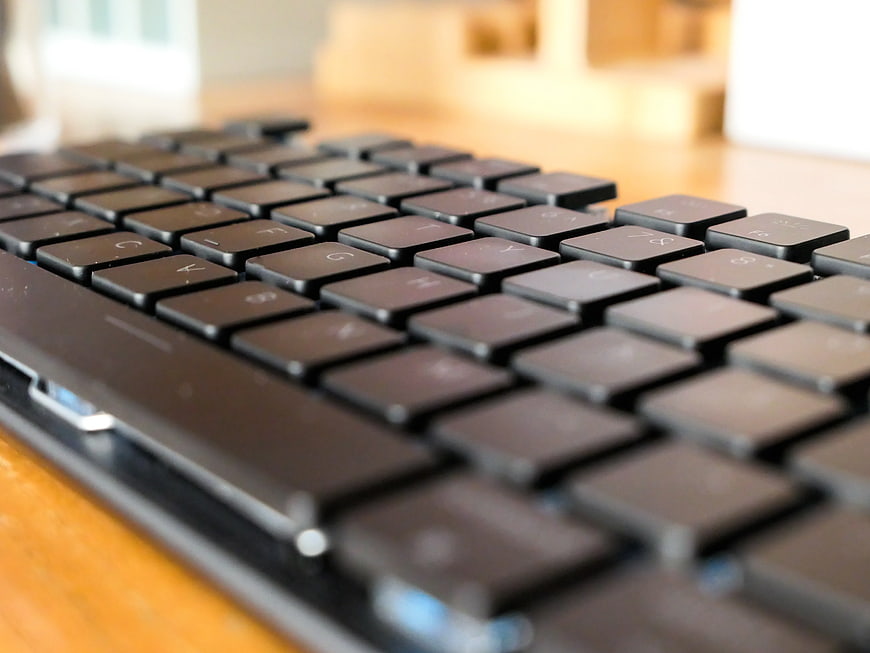 Close-up of black computer keyboard on wooden desk