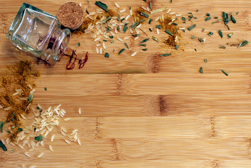 Saffron, rice, and herbs on a wooden cutting board