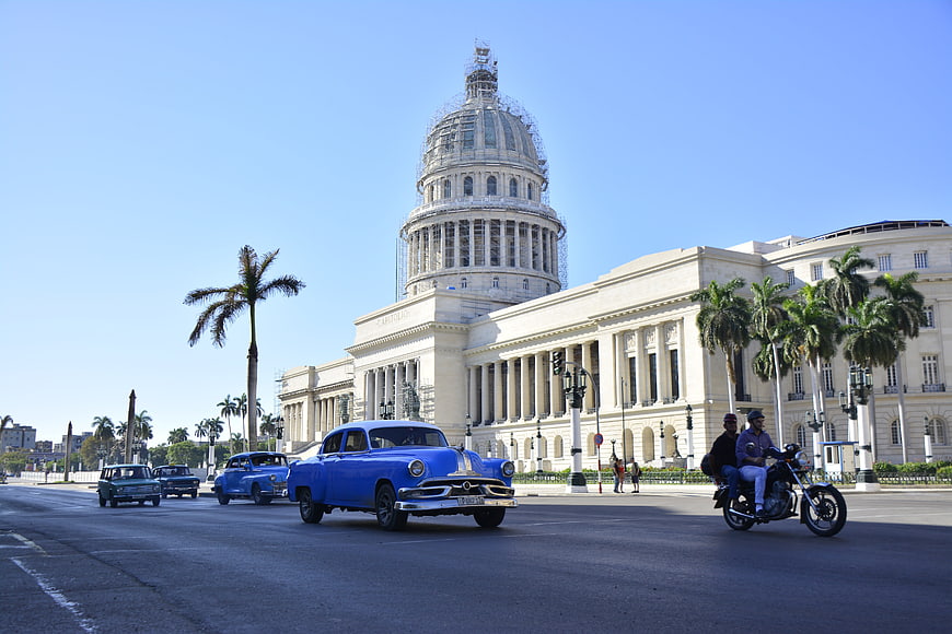 Classic Blue Car Driving Past Capitolio Building in Havana, Cuba