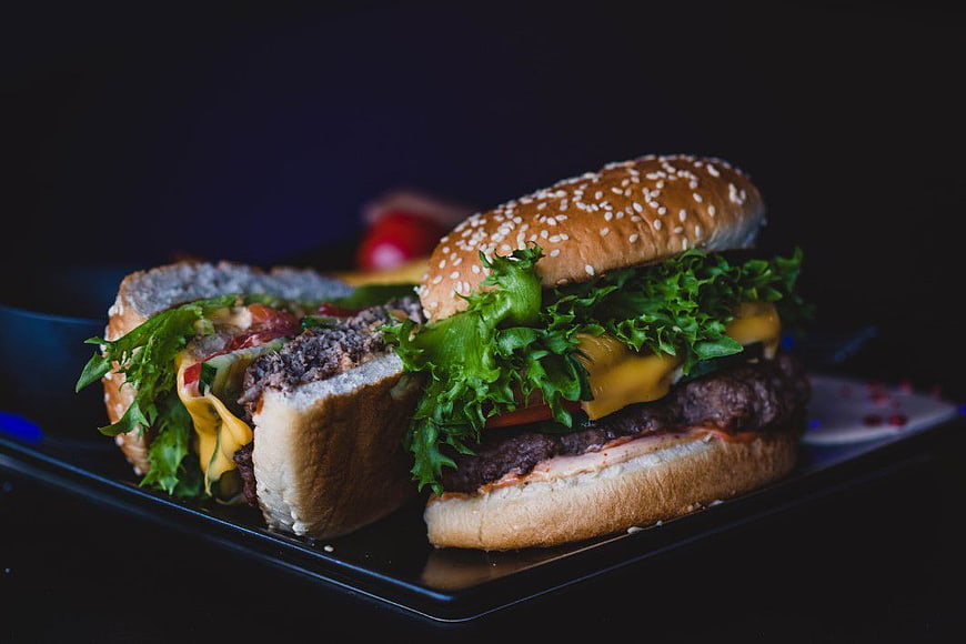 Gourmet Cheeseburger Cut in Half on Black Plate