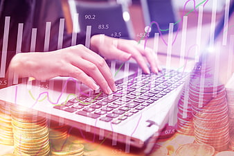 Woman Typing On Laptop With Financial Charts And Stacks Of Coins