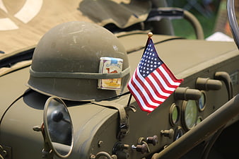 Vintage military helmet with American flag on jeep dashboard