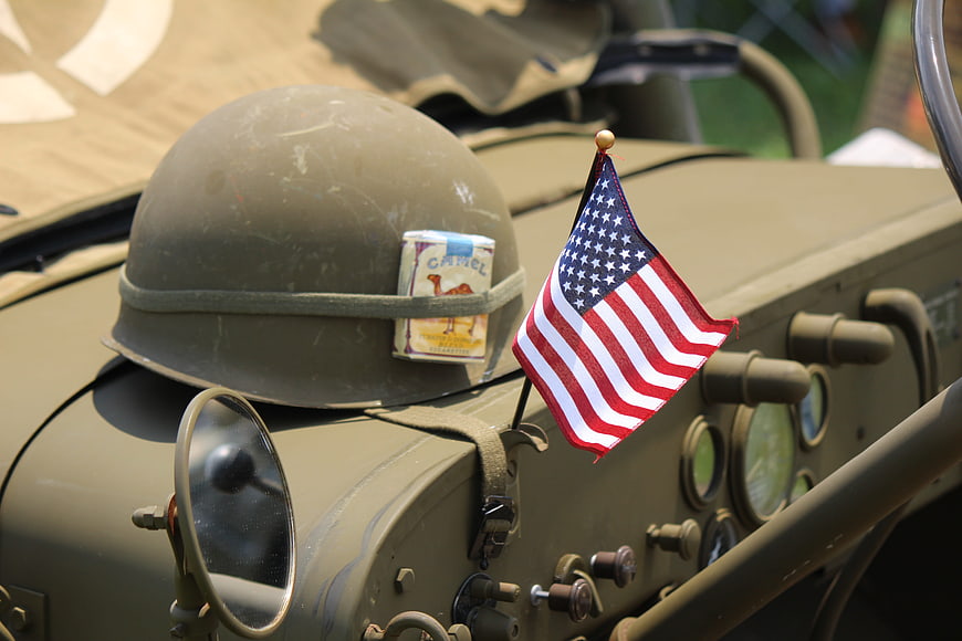 Vintage military helmet with American flag on jeep dashboard
