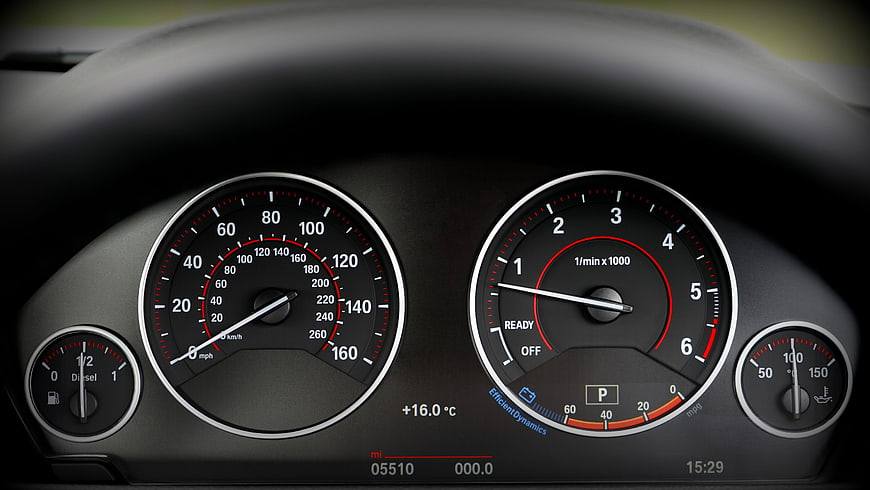 Close-up of BMW car dashboard with speedometer and tachometer