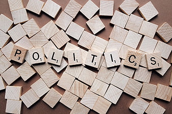 Wooden Scrabble Tiles Spelling Politics on Brown Background