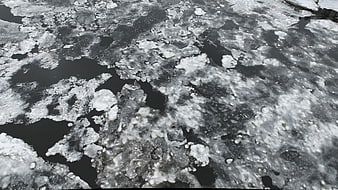 Abstract texture of melting ice and slush on dark water surface