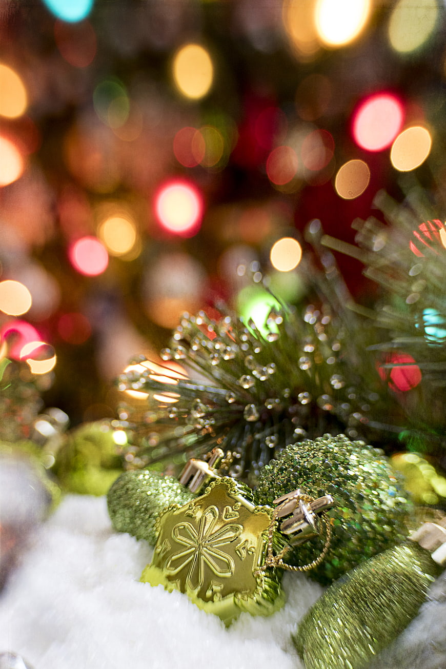 Close-up of green Christmas ornaments with bokeh lights