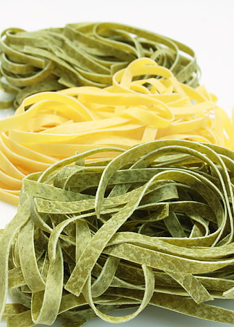Fresh Spinach and Yellow Pasta Nests on White Background