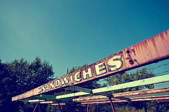 Rusty Abandoned Sandwiches Sign Against Blue Sky