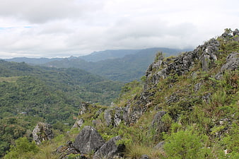Lush green mountain landscape with rocky cliffs and forest valley