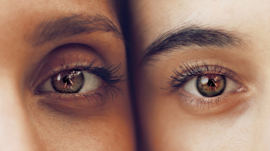 Close-up of two different eyes with distinct makeup styles