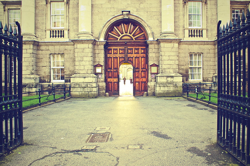 Grand stone building entrance with open wooden gates
