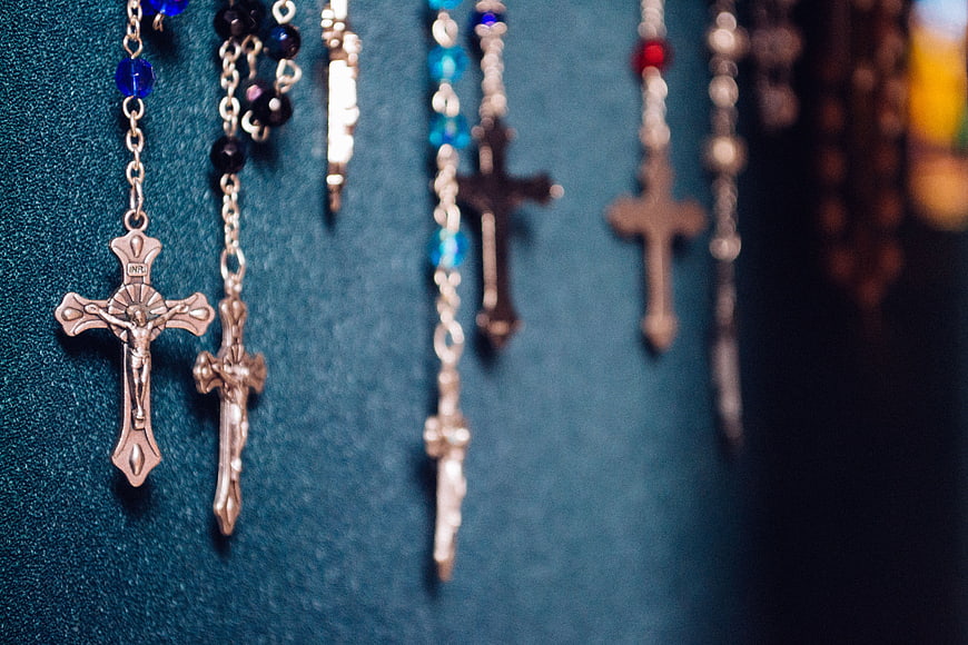 Silver Rosary Necklaces with Crosses on Blue Velvet Background