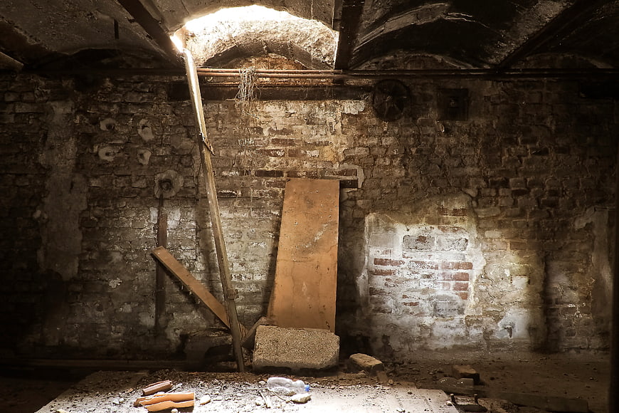 Abandoned Industrial Basement Interior With Exposed Brick Walls And Debris