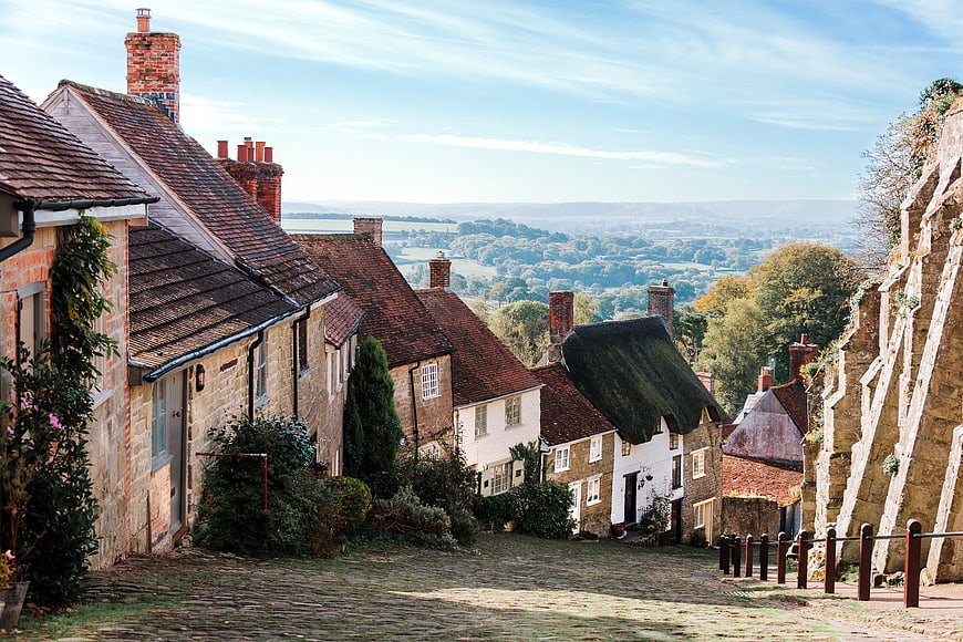 Cobblestone street in historic English village with stone cottages