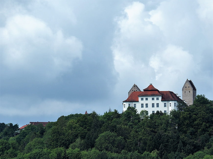 Historic white monastery with red roof on green hill