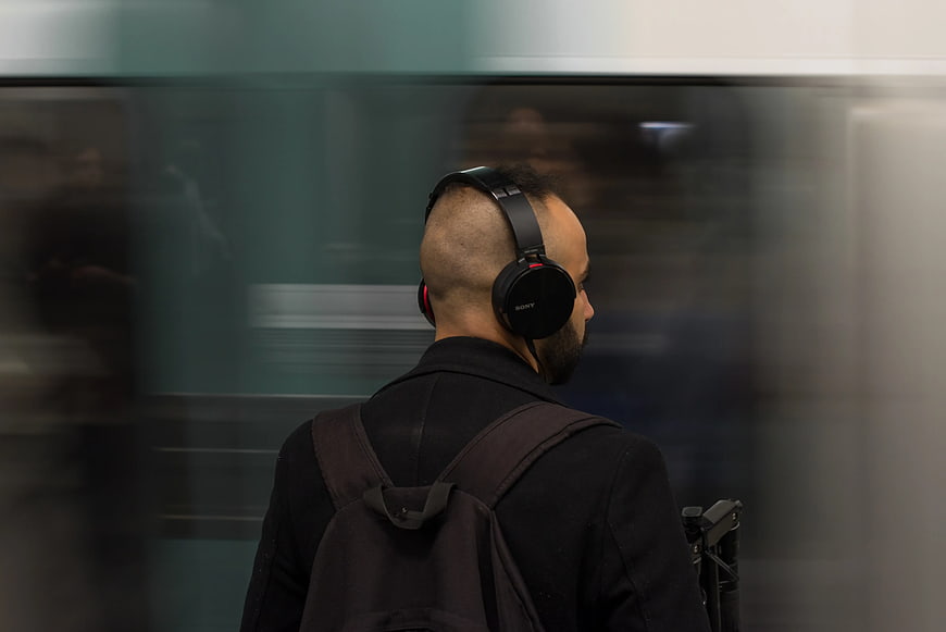 Man with headphones waiting for subway train