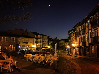 Night View of Cobblestone Square with Outdoor Cafe and Decorated Buildings