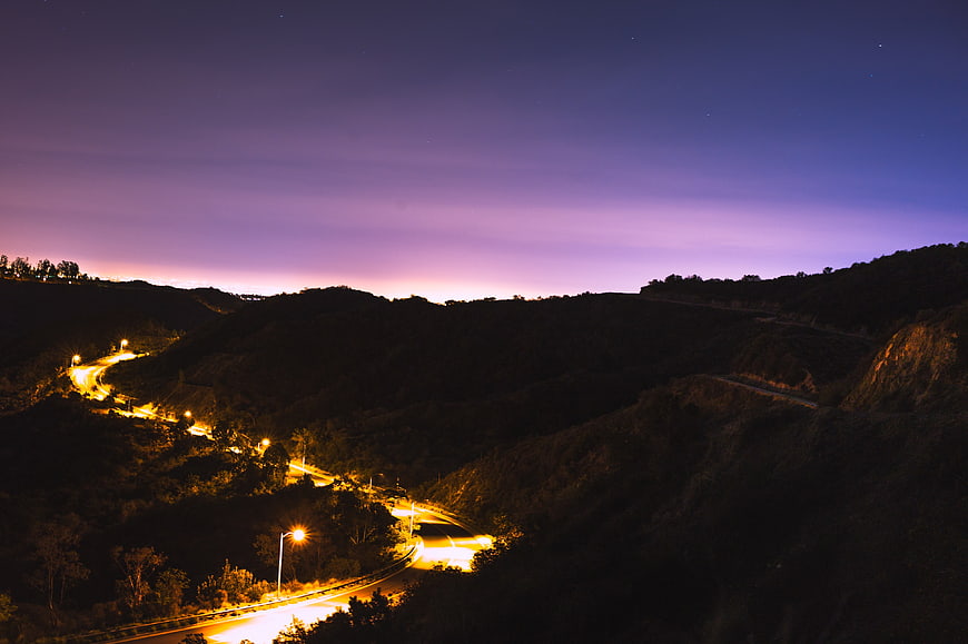 Winding Mountain Road at Twilight with Streetlights