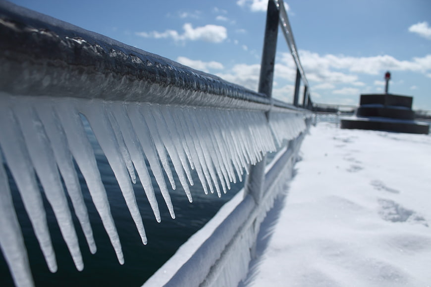 Icicles on a snowy bridge railing in winter