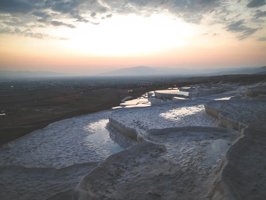 Pamukkale Travertine Terraces at Sunset with Distant City Lights