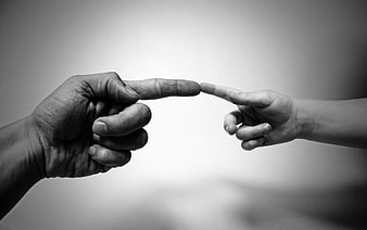 Black and white photo of adult and child fingers touching