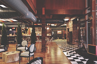 Modern industrial restaurant interior with checkered floor and exposed ducts