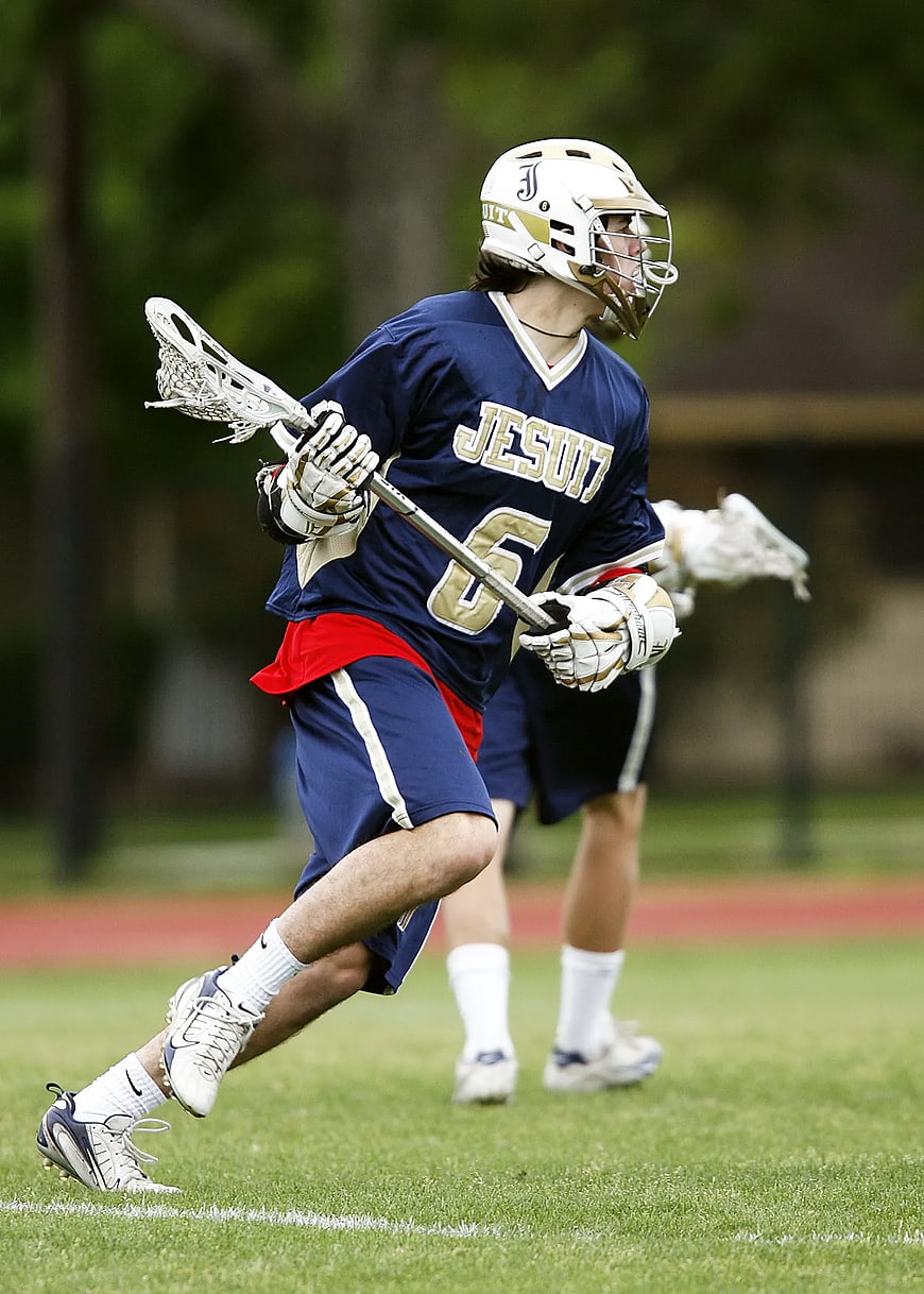 Lacrosse Player Running with Stick on Field