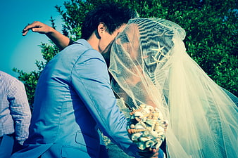 Beach Wedding Couple Kissing Under Veil with Shell Bouquet