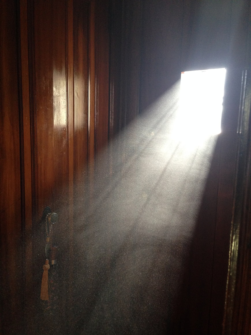 Sunlight beam streaming through dark wooden door window