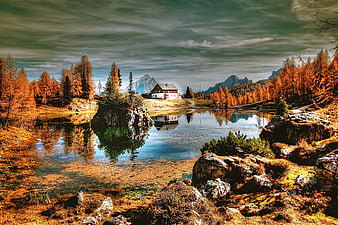 Alpine lake with autumn larch trees and mountain reflection