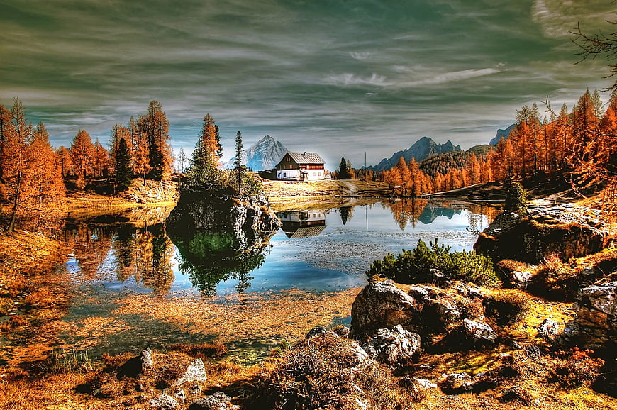 Alpine lake with autumn larch trees and mountain reflection