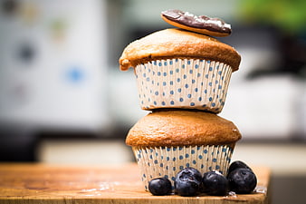 Stacked blueberry muffins with cookie on wooden board
