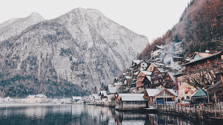 Traditional Alpine Village on Lake Shore with Mountains