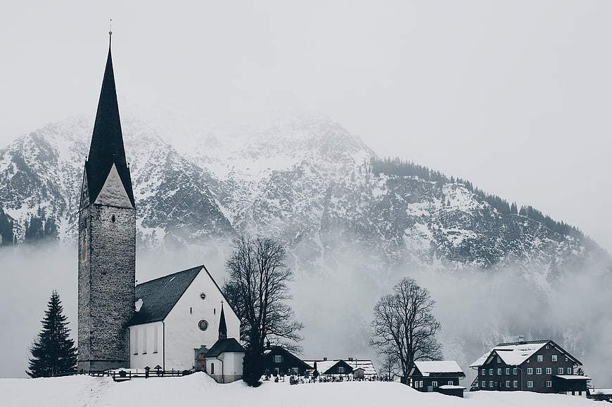 Snowy Church and Village in Alpine Winter Landscape