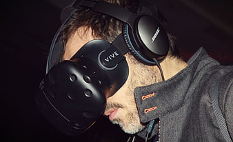 Man Wearing HTC Vive VR Headset and Bose Headphones
