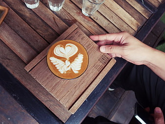 Overhead view of latte art coffee on wooden table