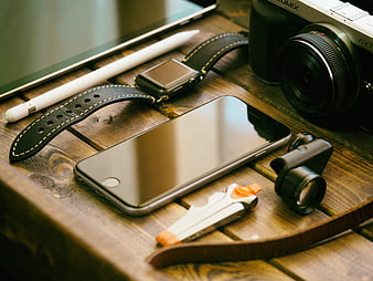 Tech gadgets on wooden table with camera and smartphone