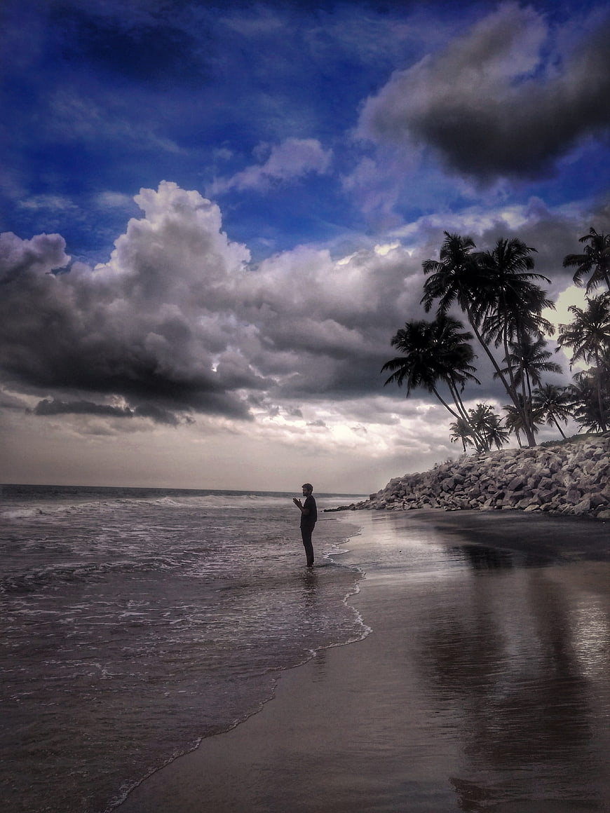 Silhouette of Man Standing on Tropical Beach with Palm Trees