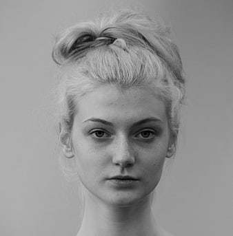 Black and white portrait of a woman with messy bun