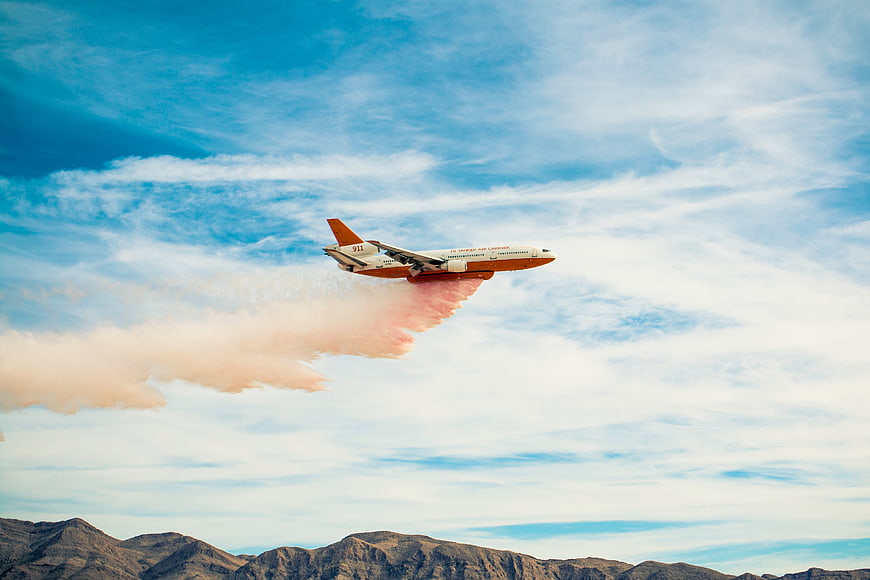 Air Tanker Dropping Fire Retardant Over Mountains